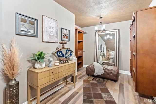 sitting room with a chandelier, hardwood / wood-style floors, and a textured ceiling