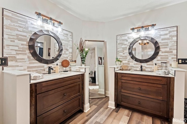 bathroom with hardwood / wood-style flooring, vanity, and decorative backsplash