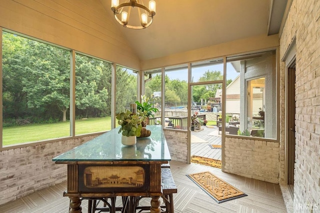 sunroom featuring a notable chandelier and lofted ceiling