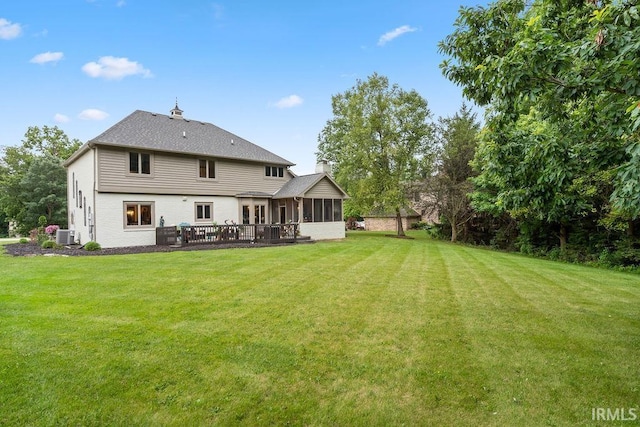 back of property with a sunroom and a yard