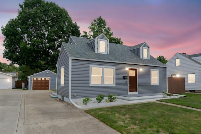 cape cod-style house with a yard, an outbuilding, and a garage