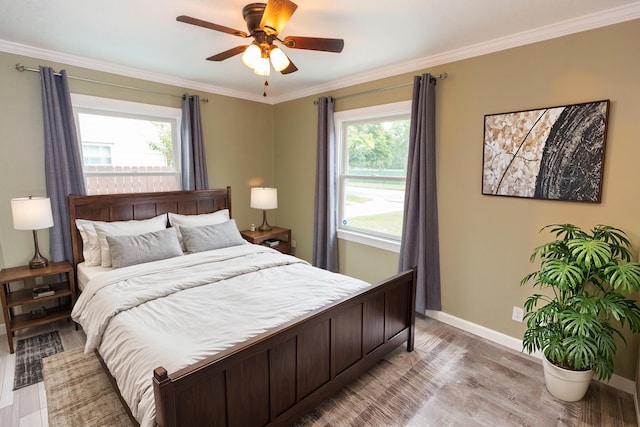 bedroom featuring multiple windows, light hardwood / wood-style floors, and ceiling fan