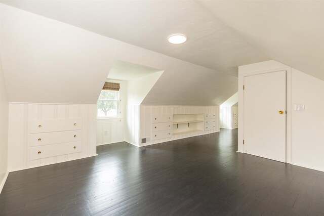 additional living space with built in shelves, dark hardwood / wood-style floors, and vaulted ceiling