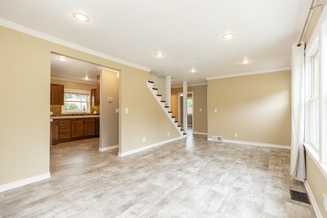 unfurnished room with sink, light wood-type flooring, and crown molding