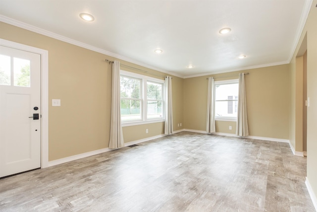 foyer entrance with crown molding, a healthy amount of sunlight, and light wood-type flooring