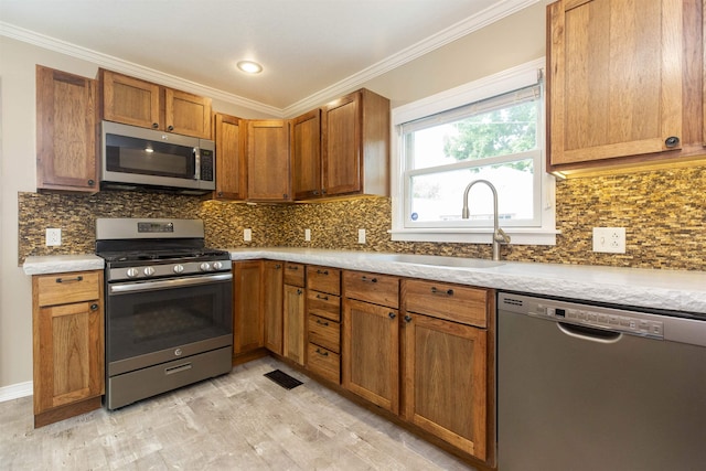 kitchen featuring backsplash, sink, stainless steel appliances, and ornamental molding