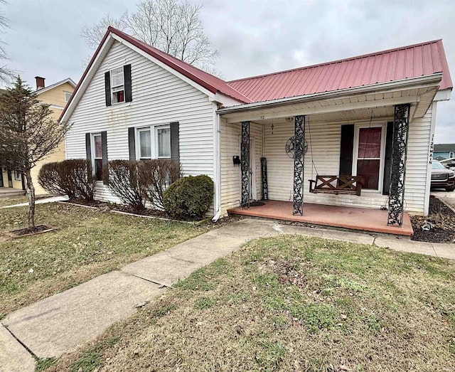 view of front of home with covered porch and a front lawn