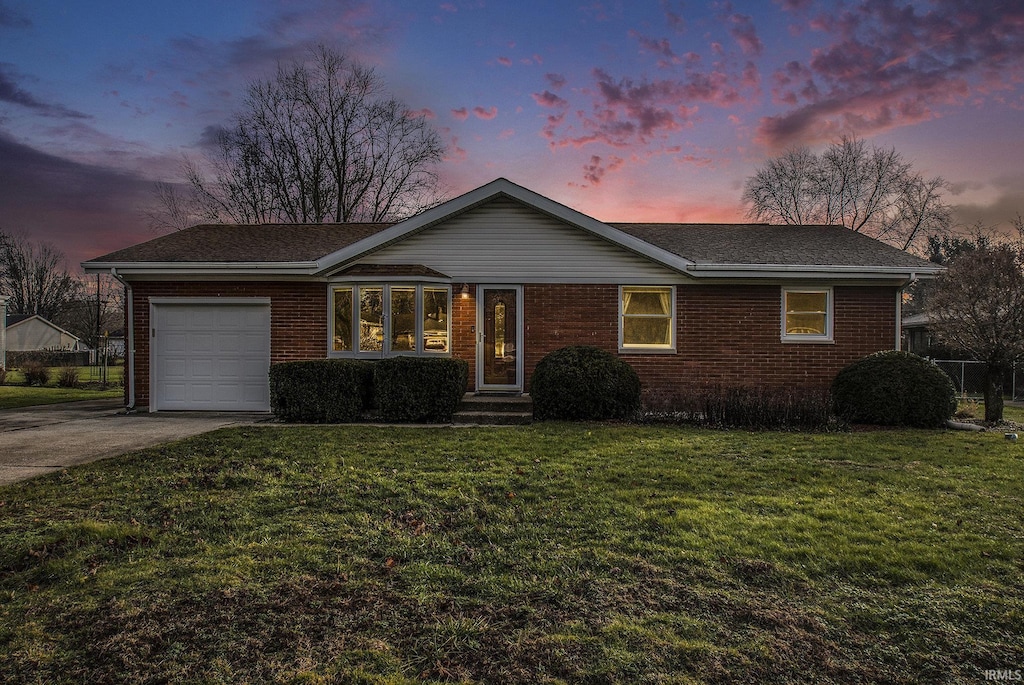 single story home with a yard and a garage