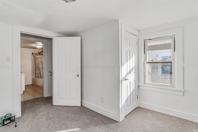 unfurnished bedroom with light colored carpet and a closet