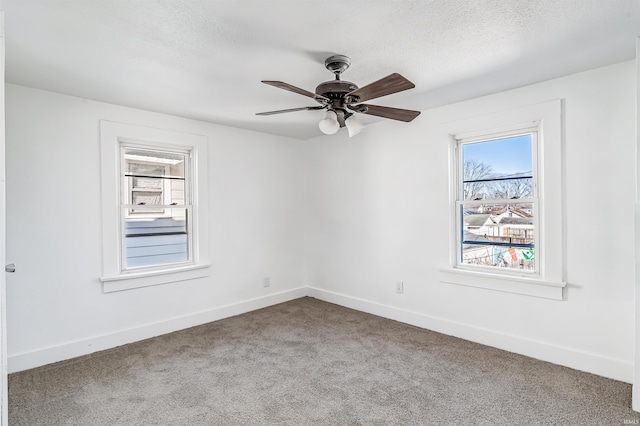 spare room featuring carpet flooring, ceiling fan, and a textured ceiling