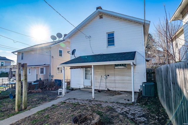 rear view of property with central AC