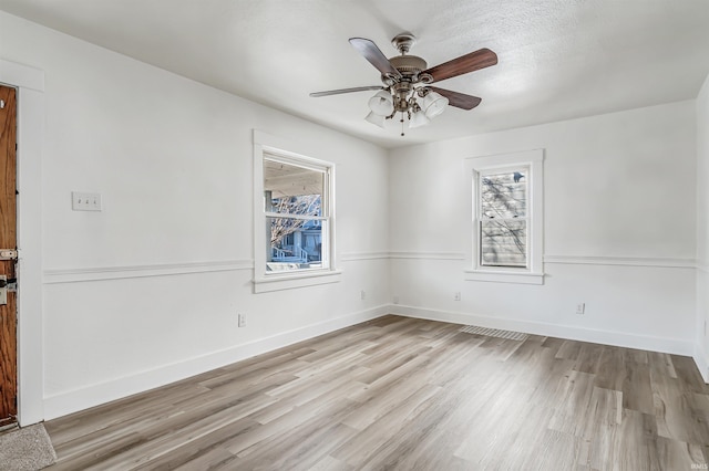 empty room with ceiling fan and light wood-type flooring