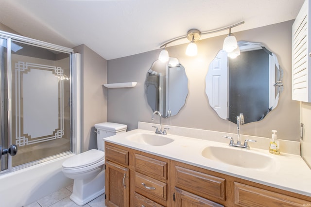 full bathroom with tile patterned floors, vanity, toilet, and bath / shower combo with glass door