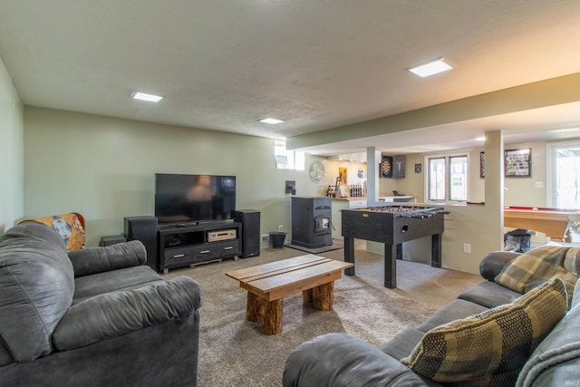 living room with light carpet, a textured ceiling, a wood stove, and billiards