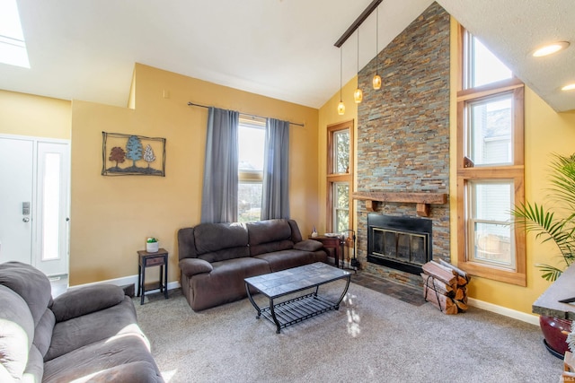 carpeted living room with a stone fireplace and high vaulted ceiling