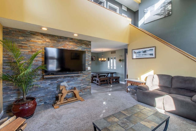 carpeted living room featuring a chandelier and a high ceiling