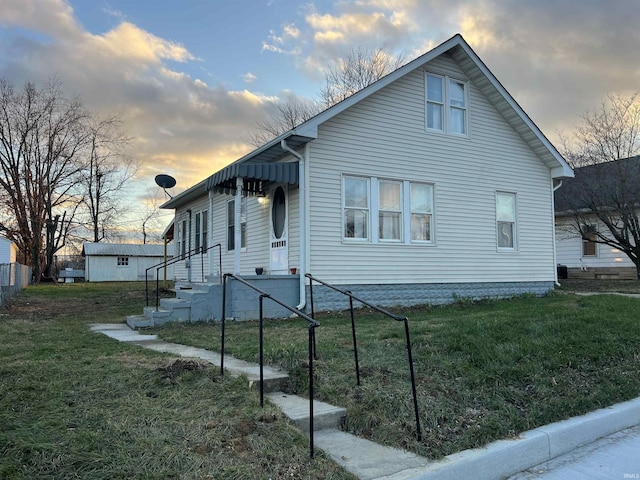 property exterior at dusk with a lawn