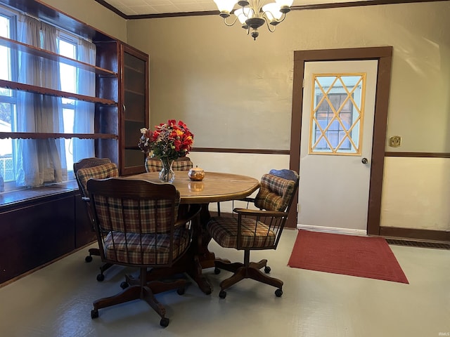 dining room featuring ornamental molding, a notable chandelier, and a healthy amount of sunlight