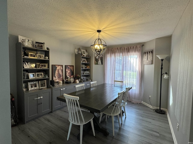 dining area featuring wood-type flooring, a textured ceiling, and an inviting chandelier