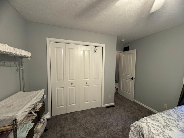 carpeted bedroom featuring a closet and a textured ceiling