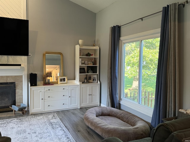 living area with a tile fireplace and light hardwood / wood-style flooring