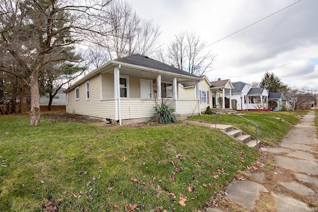 bungalow-style house featuring covered porch and a front yard