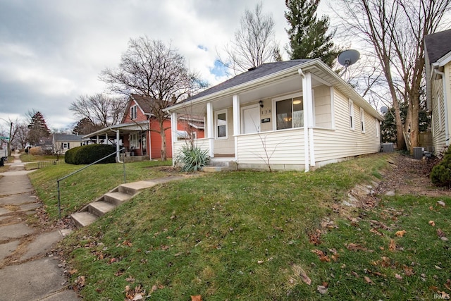 view of front facade with central AC, a porch, and a front yard