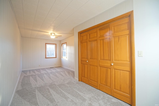 unfurnished bedroom with light carpet and a closet