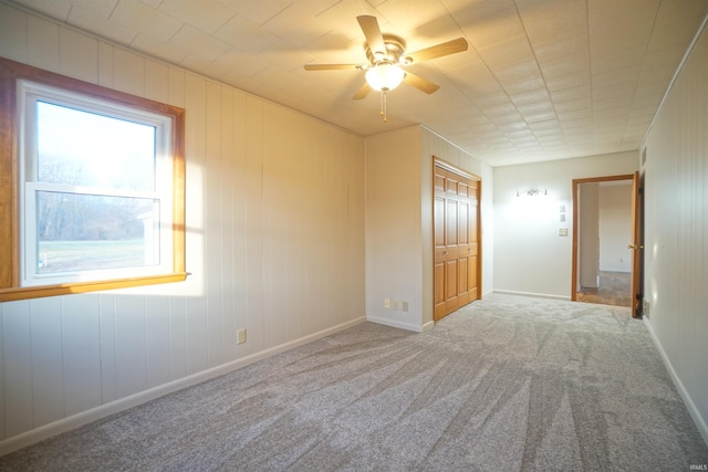 carpeted spare room featuring ceiling fan