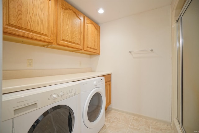 washroom with washer and dryer, light tile patterned floors, and cabinets