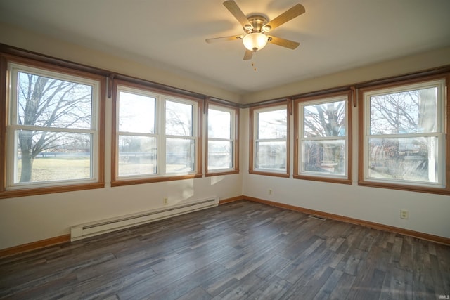 unfurnished sunroom with ceiling fan, a healthy amount of sunlight, and a baseboard heating unit