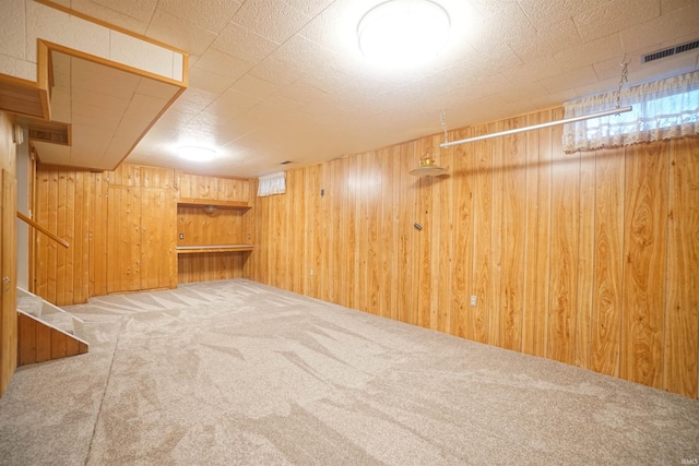 basement featuring carpet flooring and wooden walls