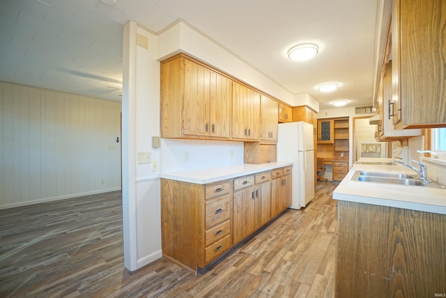 kitchen with hardwood / wood-style floors, white fridge, and sink