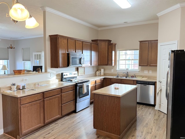 kitchen with sink, a center island, stainless steel appliances, and ornamental molding