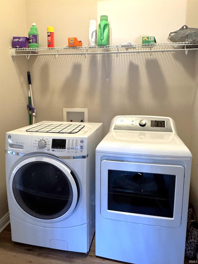 clothes washing area featuring hardwood / wood-style floors and independent washer and dryer