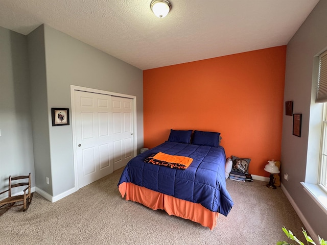 carpeted bedroom featuring a textured ceiling and a closet