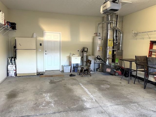 garage featuring sink, white fridge, a garage door opener, and gas water heater