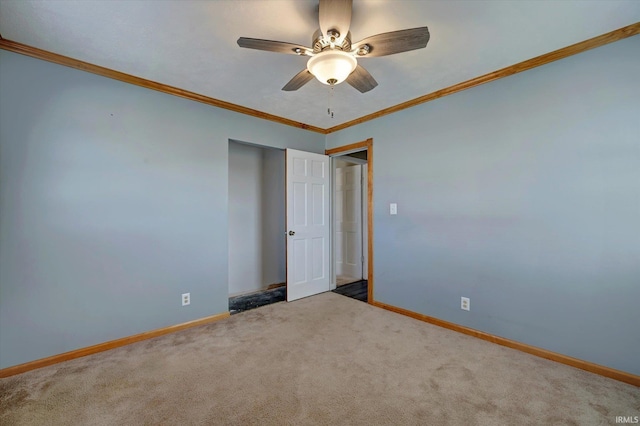 carpeted spare room with ceiling fan and crown molding