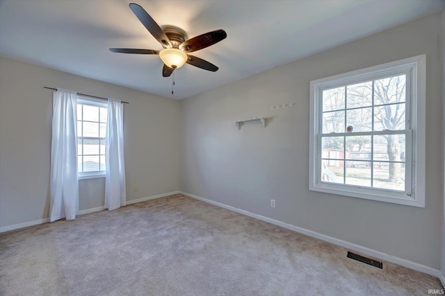 empty room with ceiling fan and light carpet