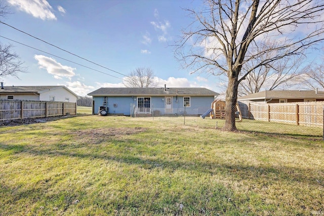 back of house with a lawn and a playground