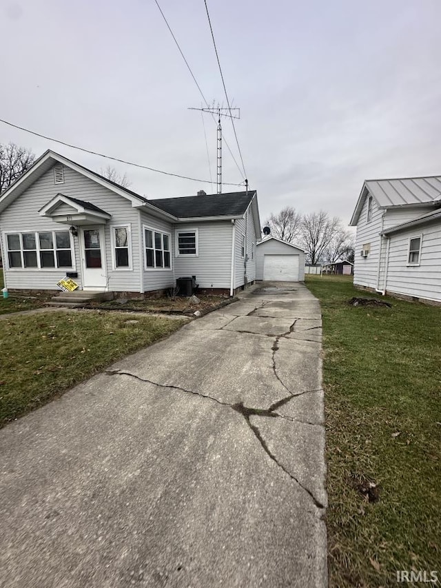 view of front of property with a front yard, a garage, and an outdoor structure