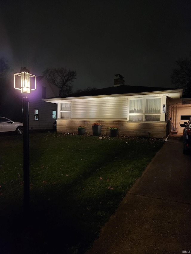 view of front of property with a garage and a lawn