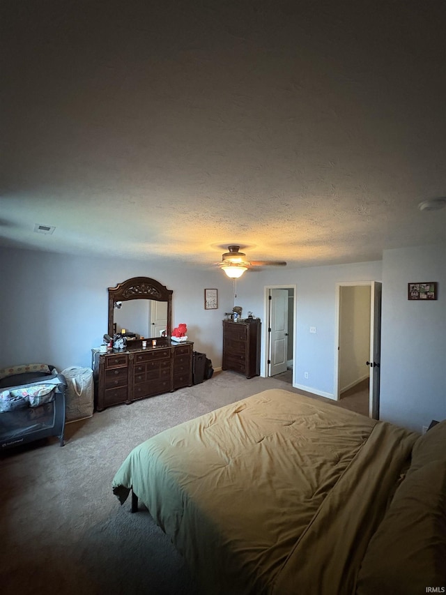 bedroom with a textured ceiling, carpet floors, and ceiling fan