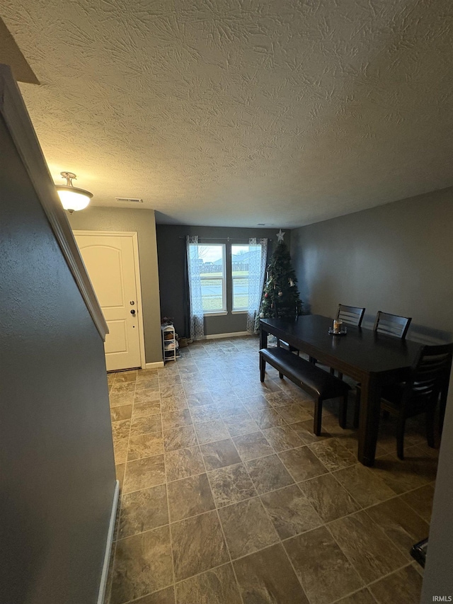 dining area featuring a textured ceiling