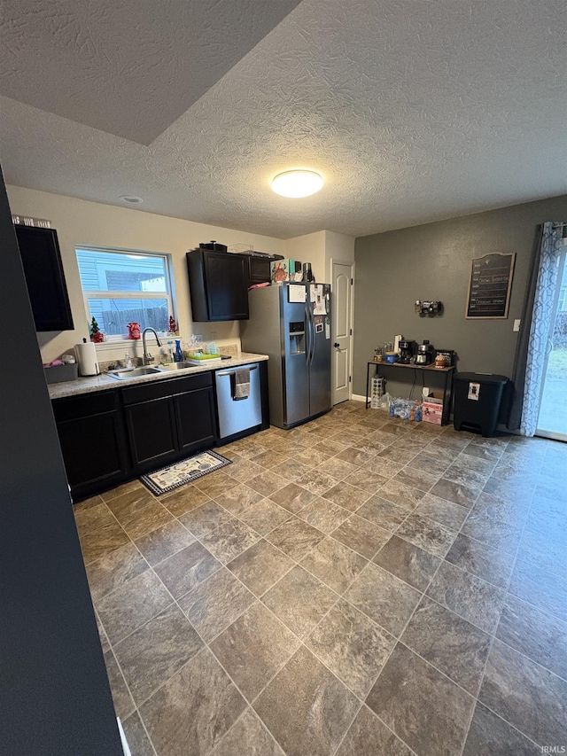 kitchen with sink, a textured ceiling, and appliances with stainless steel finishes