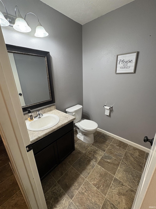 bathroom featuring vanity, a textured ceiling, and toilet