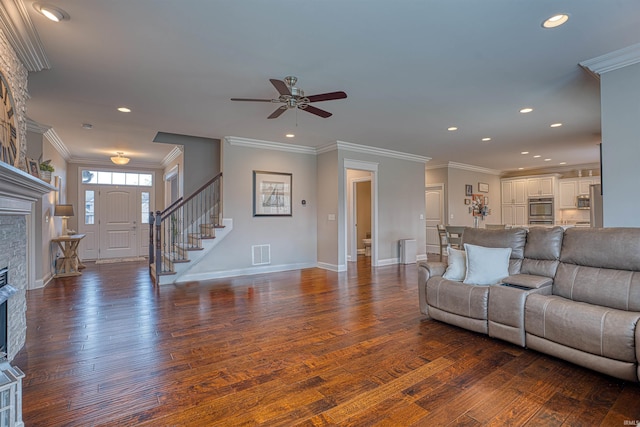 living room featuring a stone fireplace, dark wood-type flooring, and ornamental molding