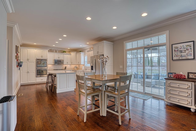 dining area featuring radiator heating unit, dark hardwood / wood-style floors, crown molding, and sink