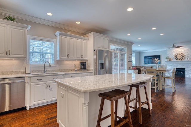 kitchen featuring a kitchen island, sink, white cabinetry, and stainless steel appliances