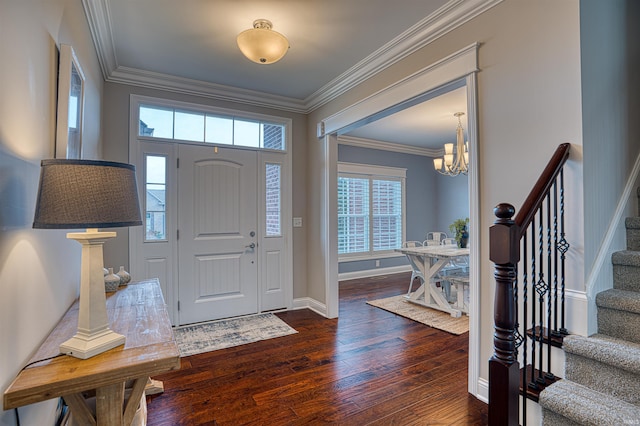 foyer with ornamental molding, dark wood-type flooring, and a chandelier